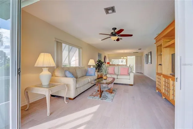 a living room with furniture a chandelier and a window