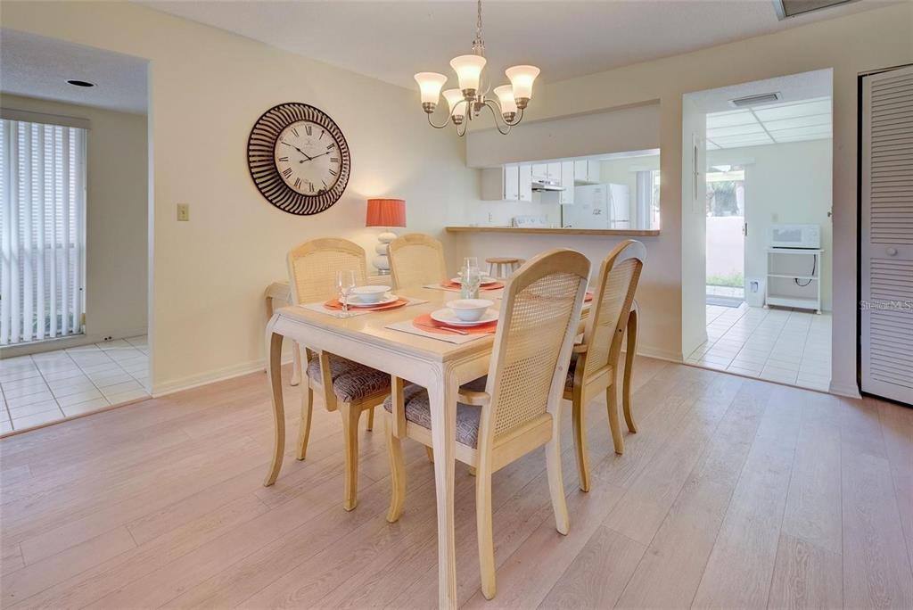 314 Cerromar Way, Unit 16 Venice, FL 34293 - Photo 8 of 47 a dining room with wooden floor a chandelier a wooden table and chairs