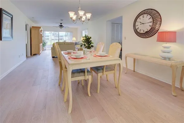 a view of a dining room with furniture a chandelier and wooden floor