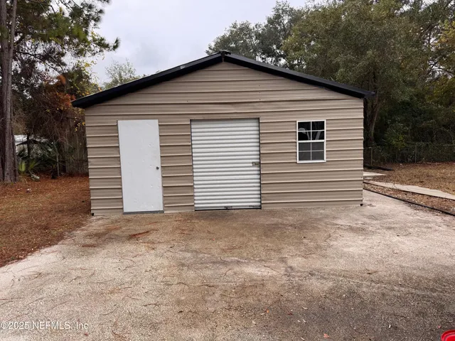 a view of a white house with a yard and garage