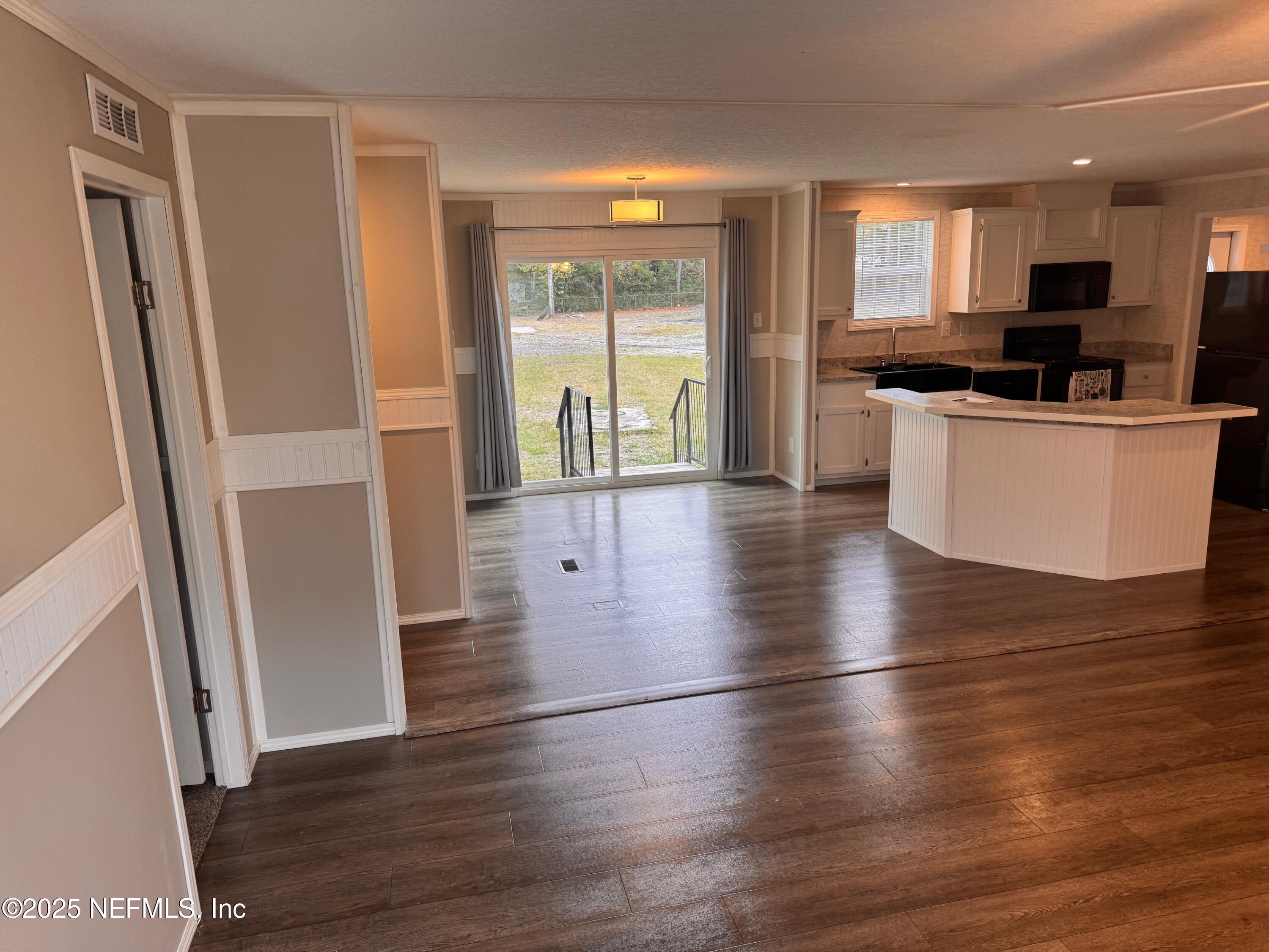 95608 Clearwater Road Fernandina Beach, FL 32034 - Photo 12 of 32 a kitchen with stainless steel appliances a refrigerator stove and wooden floor