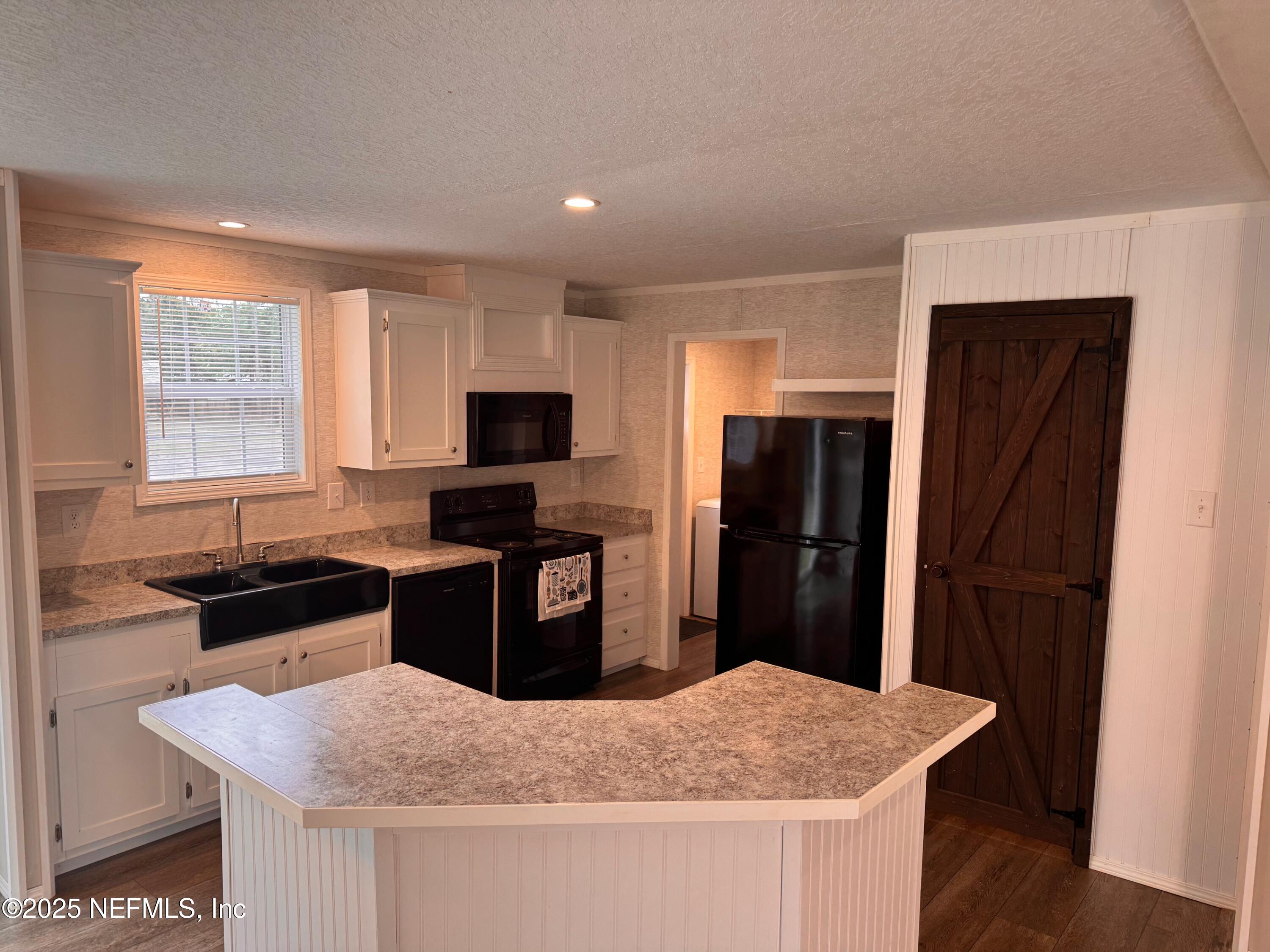 95608 Clearwater Road Fernandina Beach, FL 32034 - Photo 13 of 32 a kitchen with granite countertop cabinets and refrigerator
