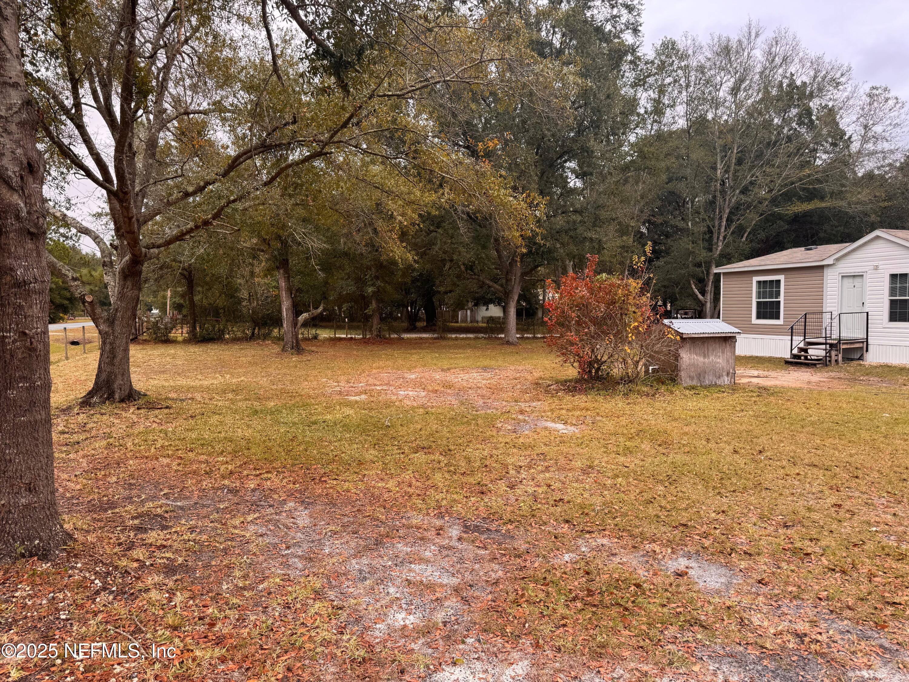 95608 Clearwater Road Fernandina Beach, FL 32034 - Photo 7 of 32 a backyard of a house with table and chairs