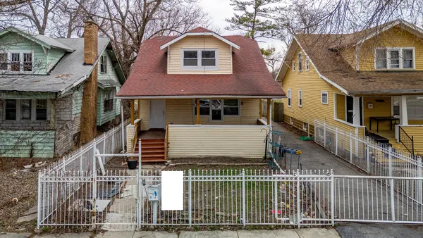 a view of a house with wooden fence