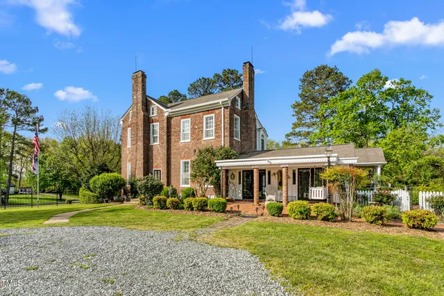 a view of a house with a yard and sitting area