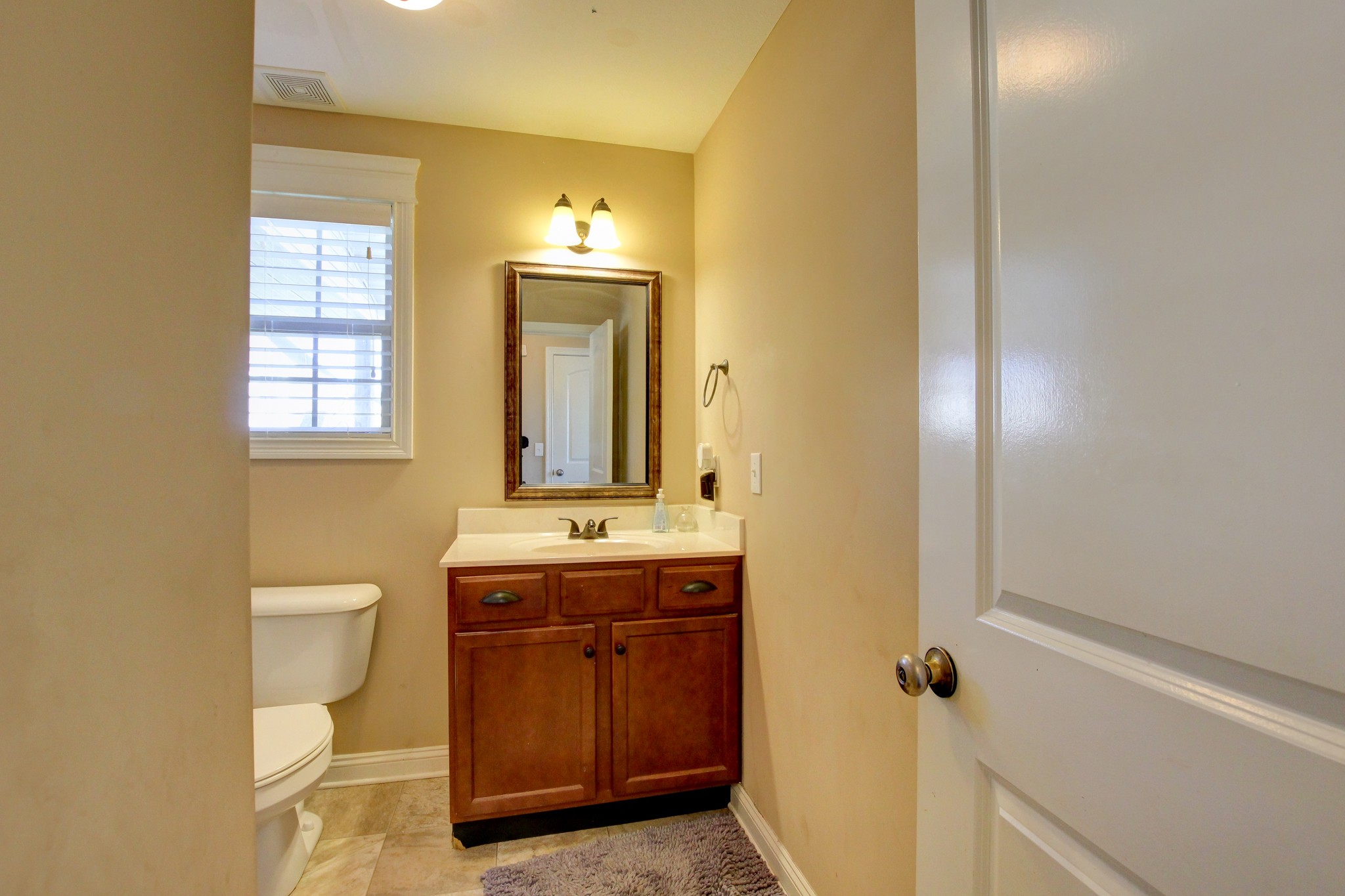 3776 Suiter Road Clarksville, TN 37040 - Photo 5 of 16 a bathroom with a granite countertop toilet a sink and a mirror