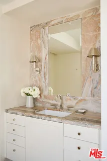 a bathroom with a granite countertop sink a mirror and shower