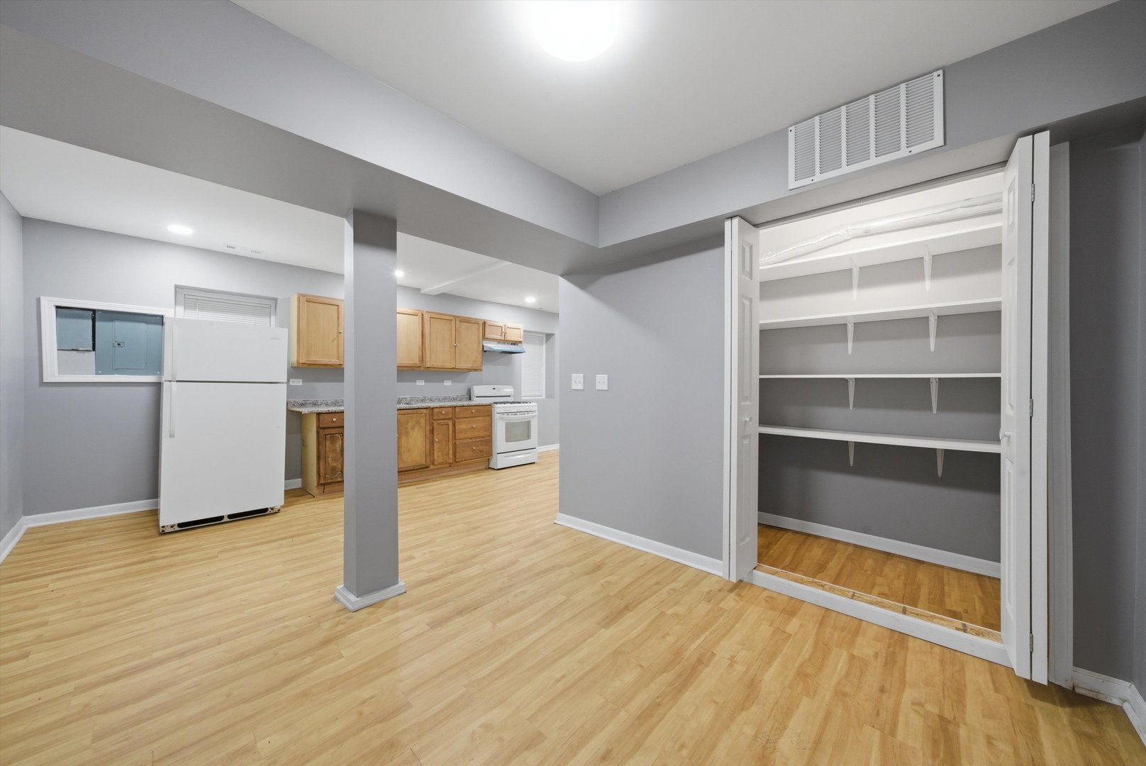 7828 South Escanaba Avenue Chicago, IL 60649 - Photo 35 of 41 a view of an empty room with wooden floor and a cabinet