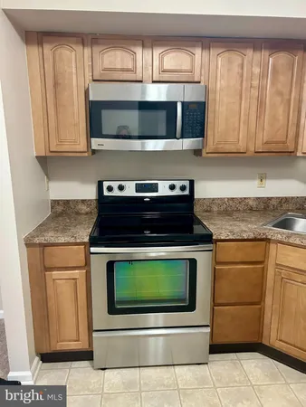 a kitchen with granite countertop a stove top oven microwave and cabinets
