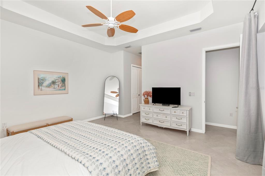 17475 Jadestone Court Venice, FL 34293 - Photo 21 of 100 a bedroom with a bed and a television