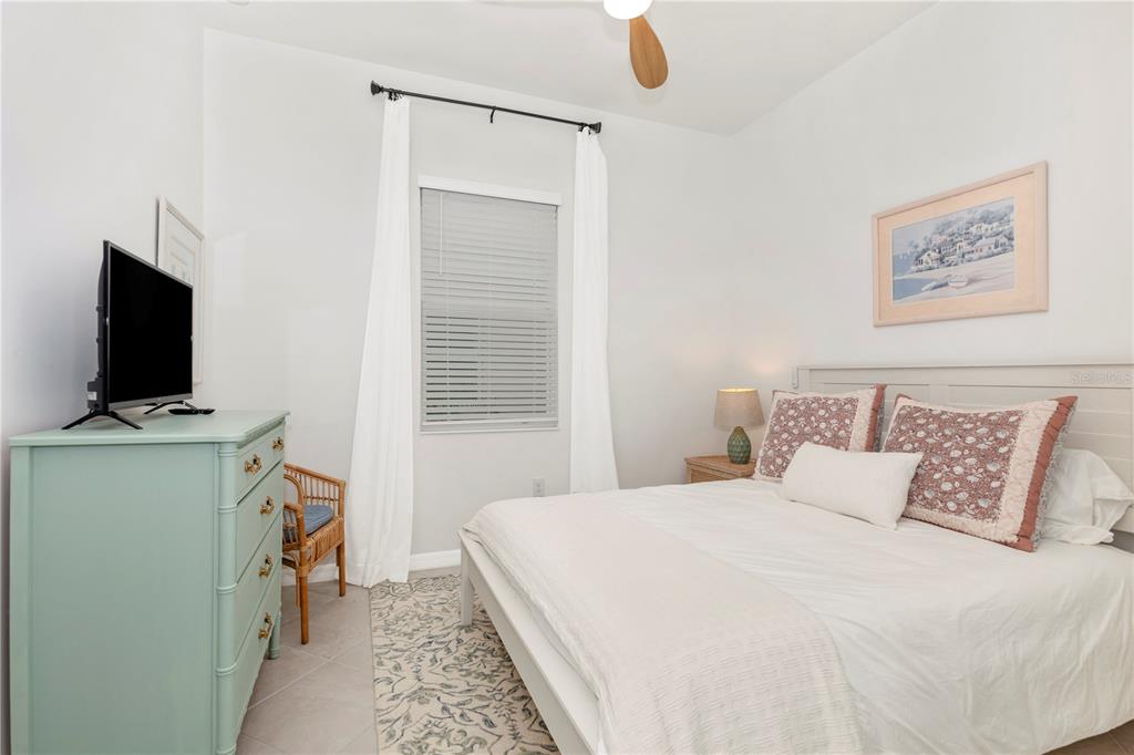17475 Jadestone Court Venice, FL 34293 - Photo 27 of 100 a bedroom with a bed and a flat tv screen on a table