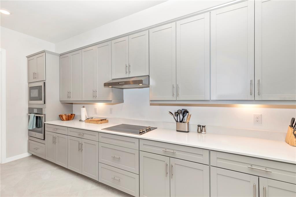 17475 Jadestone Court Venice, FL 34293 - Photo 6 of 100 a kitchen with white cabinets and white appliances