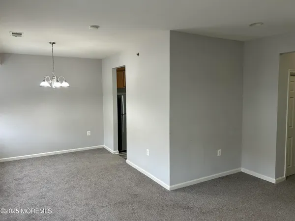 an empty room with chandelier fan
