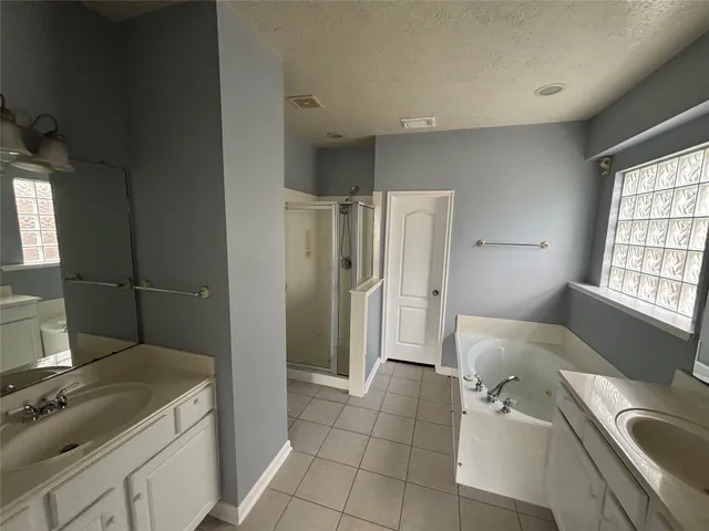 a spacious bathroom with a tub sink and a mirror