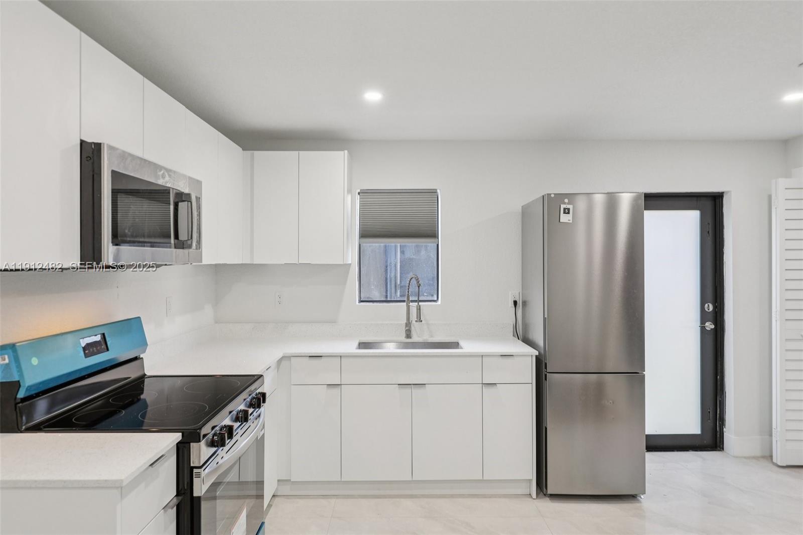 17003 Southwest 107th Place, Unit 2 Miami, FL 33157 - Photo 4 of 16 a kitchen with a sink cabinets and stainless steel appliances