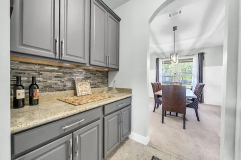 a kitchen with stainless steel appliances granite countertop a stove top oven a refrigerator a sink and a dining table with wooden floor