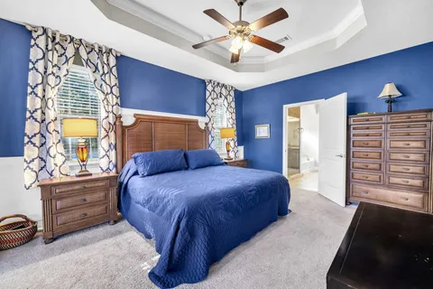 a bedroom with a bed and a large mirror on dresser