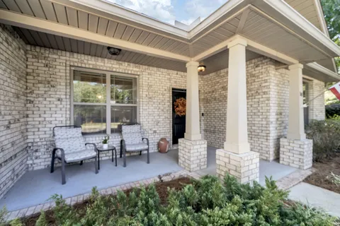 a view of living room kitchen with stainless steel appliances granite countertop a stove and large window