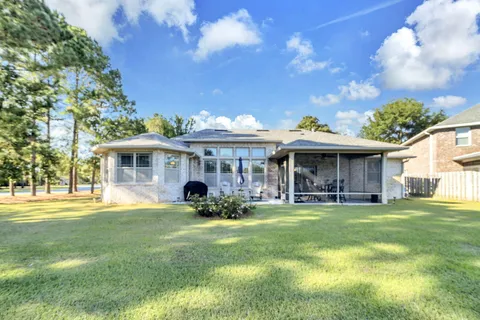 a view of house with wooden deck and outdoor seating