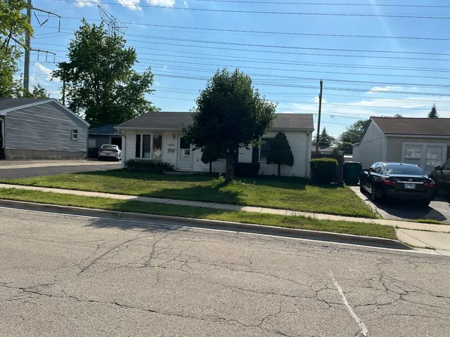 a view of a white house with a yard and plants