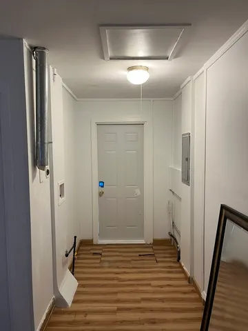 a view of a hallway with wooden floor and staircase
