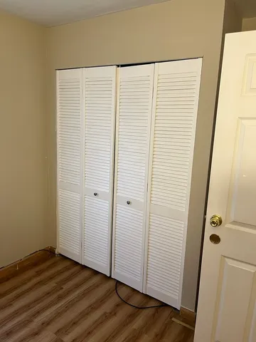 a view of a room with wooden floor and white wall