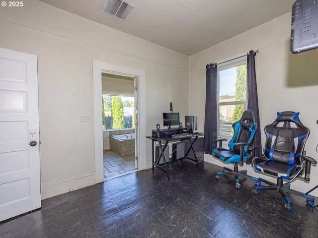 a view of a workspace with furniture and a window