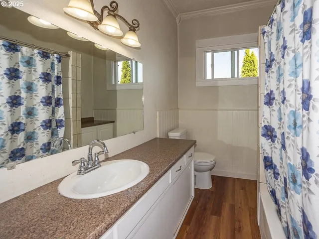 a bathroom with a granite countertop sink a toilet and a mirror