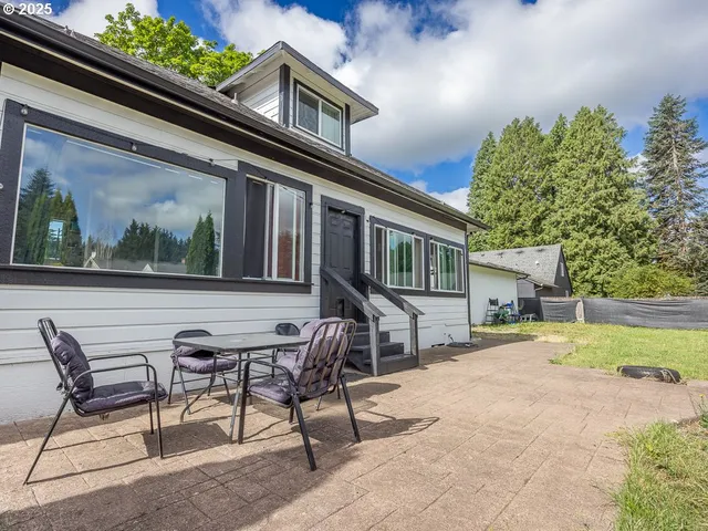 a view of a house with backyard and sitting area