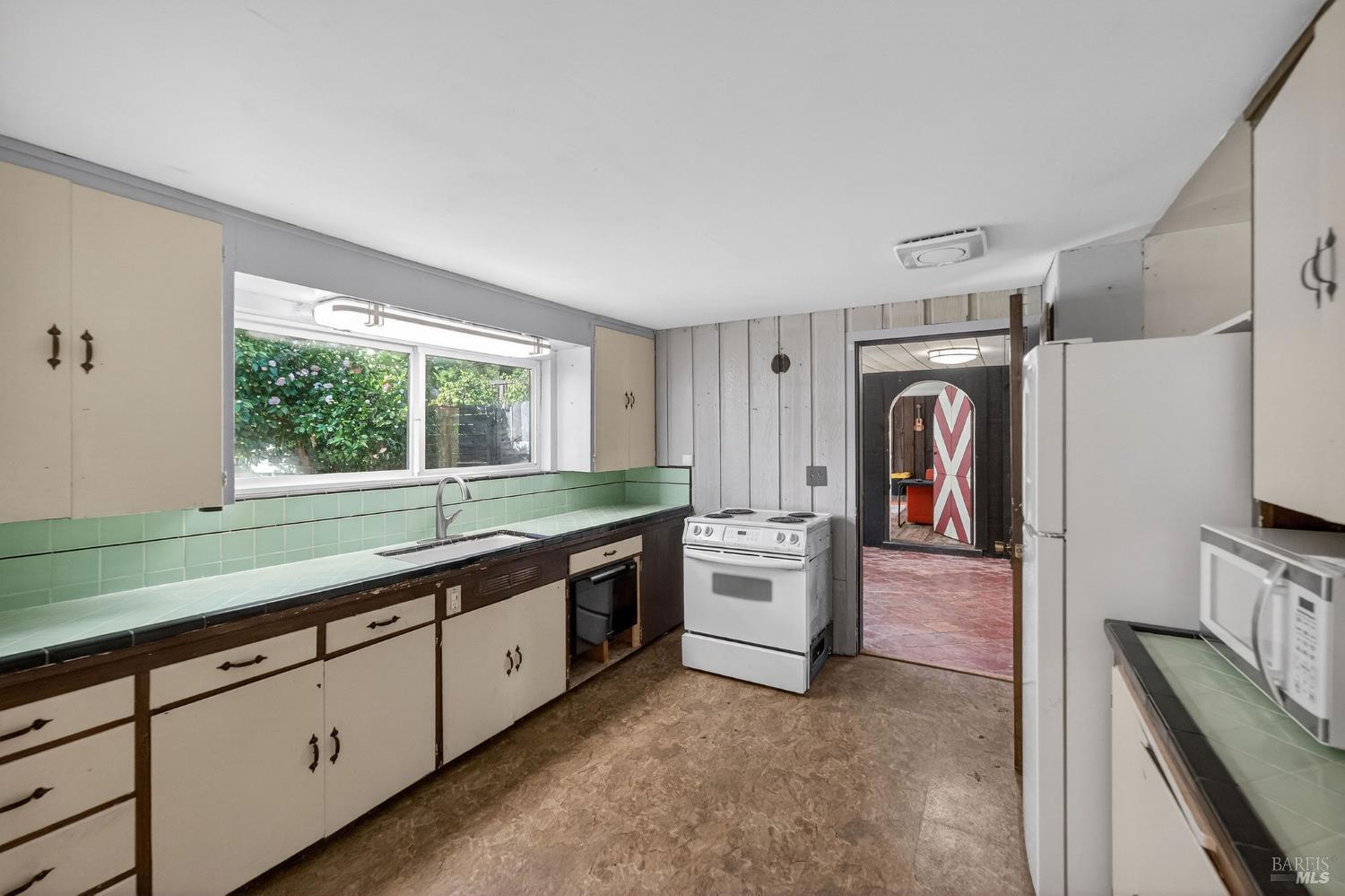 1450 Timberhill Road Santa Rosa, CA 95401 - Photo 22 of 50 a large white kitchen with stainless steel appliances granite countertop a sink and a refrigerator