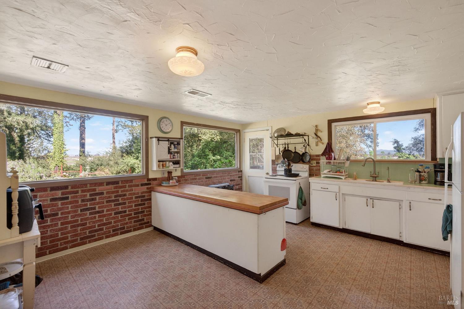 1450 Timberhill Road Santa Rosa, CA 95401 - Photo 10 of 50 a large kitchen with kitchen island a large window and stainless steel appliances