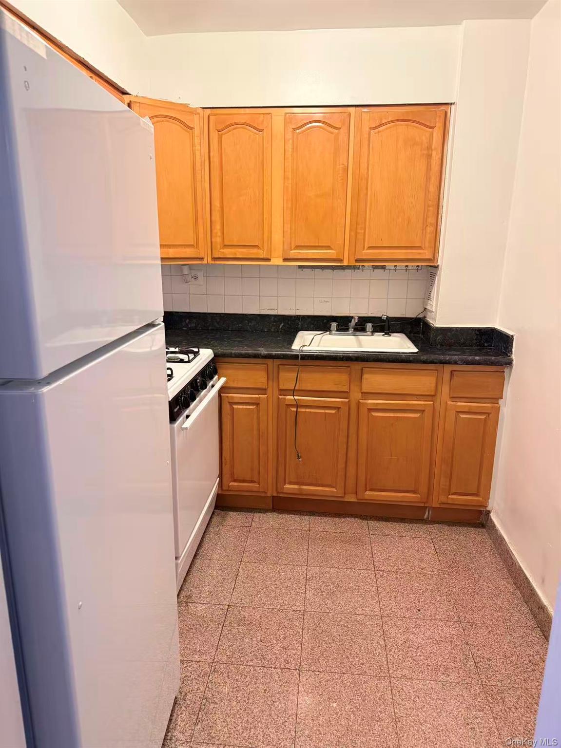 41-07 Bowne Street, Unit 1 Queens, NY 11355 - Photo 4 of 10 a kitchen with stainless steel appliances a sink and a refrigerator