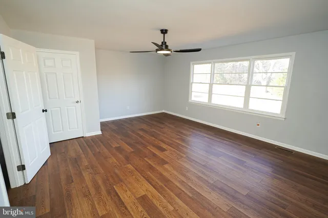wooden floor in an empty room with a window
