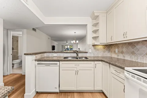 a kitchen with cabinets appliances a sink and a counter top space