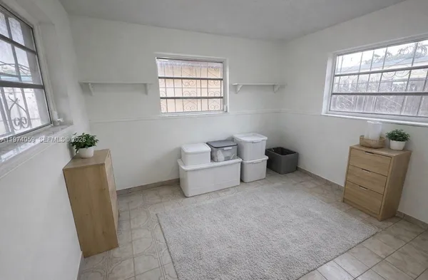 a bedroom with a bed a flat screen tv and a large window