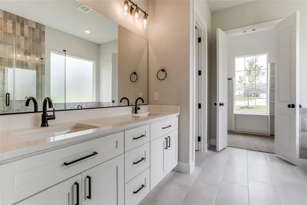 a spacious bathroom with double sink and a mirror