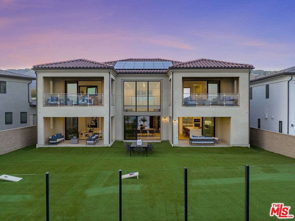 a front view of a house with a garden and plants