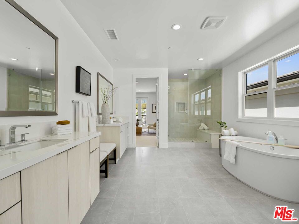 20416 Albion Way Porter Ranch, CA 91326 - Photo 21 of 38 a bathroom with a tub a double vanity sink a mirror a vanity and shower