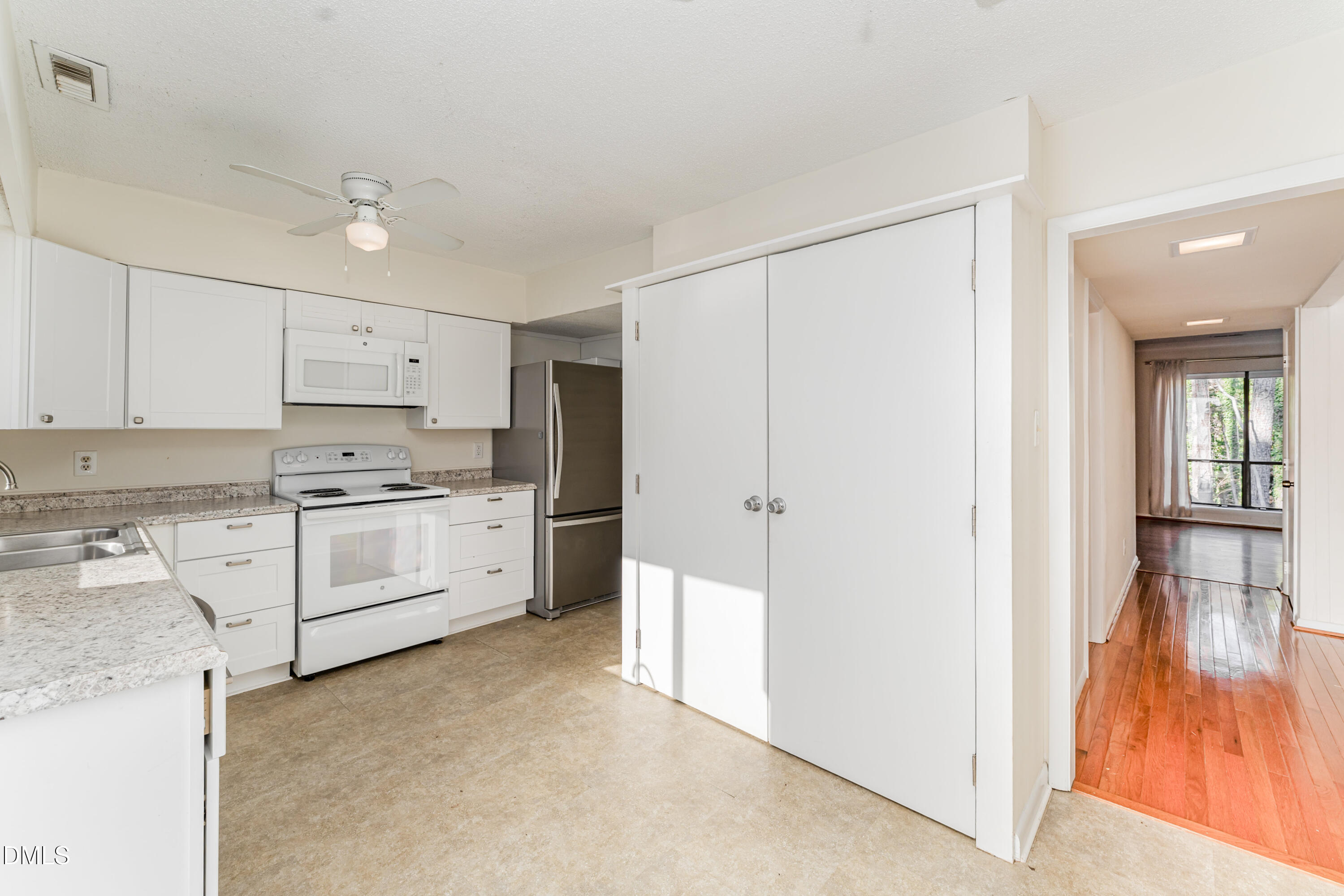 5073 Tall Pines Court Raleigh, NC 27609 - Photo 13 of 32 a kitchen with white cabinets and white appliances