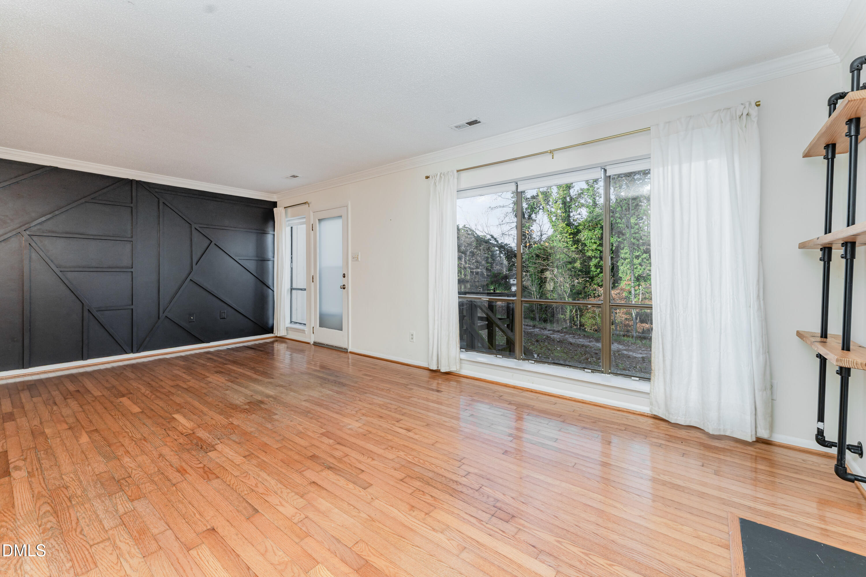 5073 Tall Pines Court Raleigh, NC 27609 - Photo 8 of 32 a view of empty room with wooden floor and fan