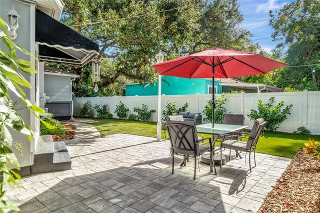 a view of a patio with table and chairs under an umbrella