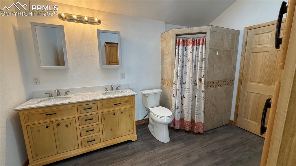 3250 Slocum Road Peyton, CO 80831 - Photo 27 of 50 a bathroom with a granite countertop sink toilet and shower