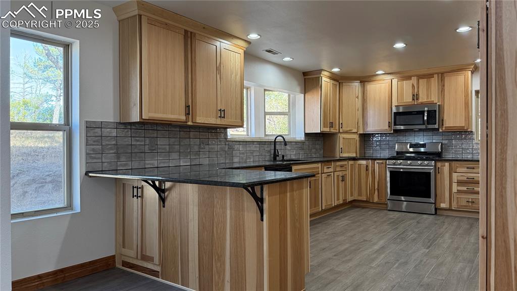 3250 Slocum Road Peyton, CO 80831 - Photo 7 of 50 a kitchen with stainless steel appliances granite countertop a stove a sink and a microwave