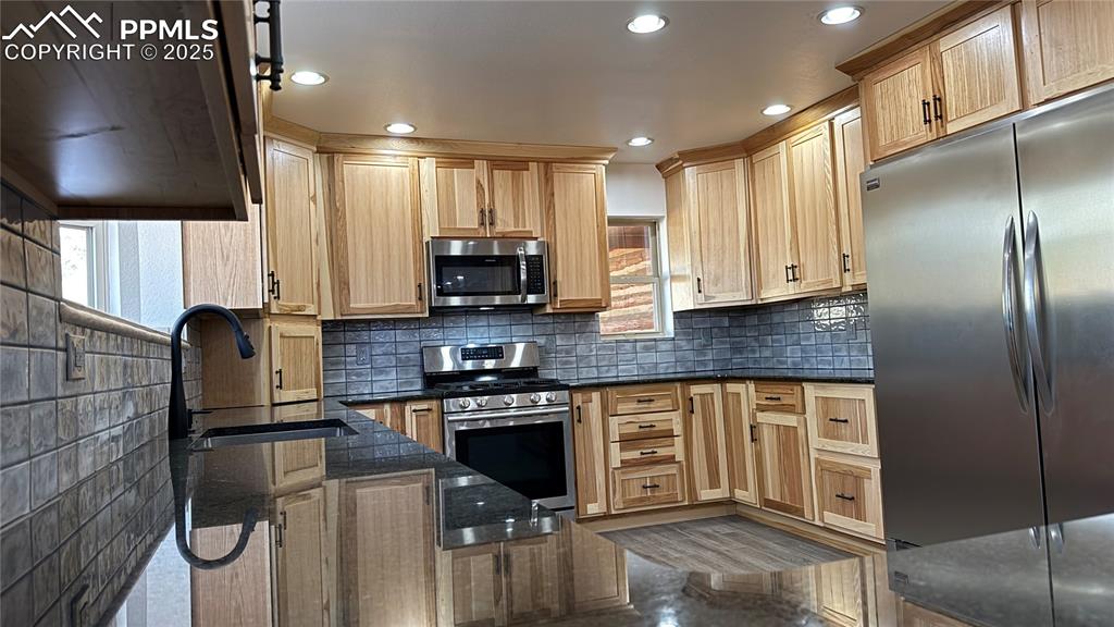 3250 Slocum Road Peyton, CO 80831 - Photo 8 of 50 a kitchen with stainless steel appliances granite countertop a stove a sink and a refrigerator