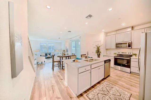 a kitchen with stainless steel appliances kitchen island granite countertop a stove a sink and a refrigerator