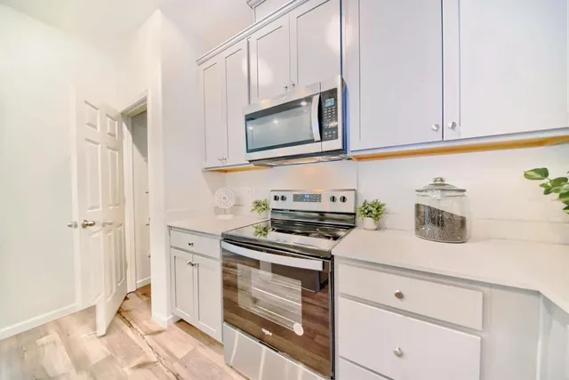a kitchen with white cabinets and appliances