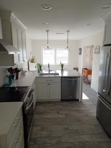 a kitchen with stainless steel appliances a sink stove and refrigerator