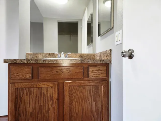 a bathroom with a granite countertop sink and a mirror