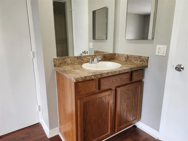 a bathroom with a granite countertop sink and a mirror