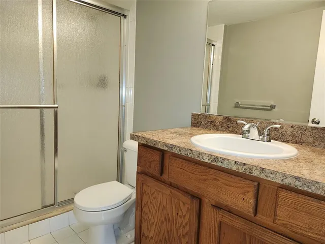 a bathroom with a granite countertop sink toilet and a mirror